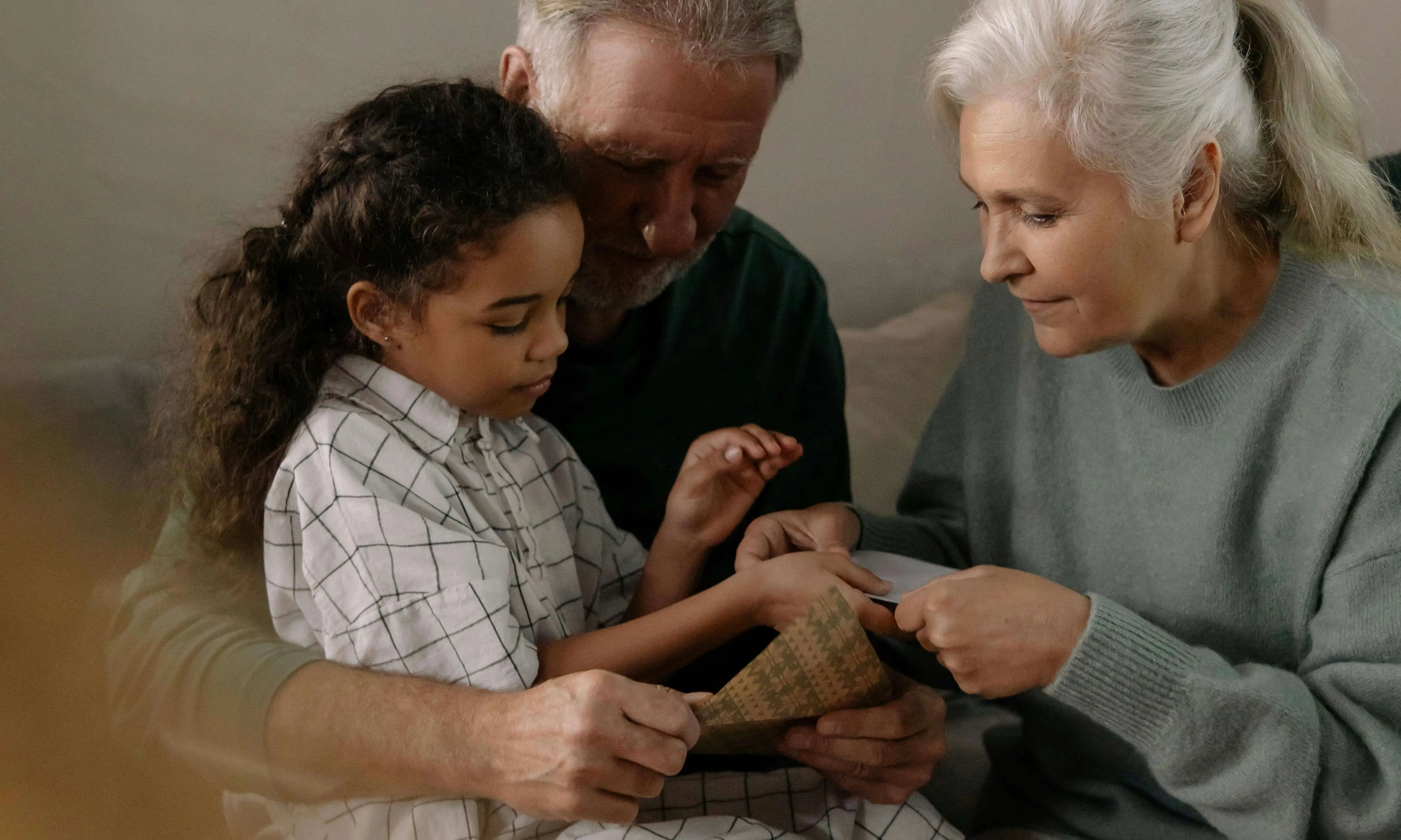 Multi-generational family - grandparents and grandchild looking at important documents together